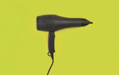 black-hair-dryer-on-orange-background-top-view-still-life-flat-lay-copy-space